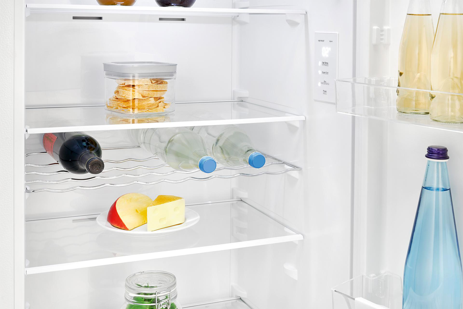 Kühlschrankinnenraum: Lebensmittel auf Regalen, darunter Flaschen, Käse und Snacks.