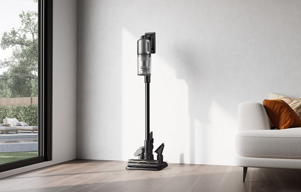 Bezprzewodowy odkurzacz stoi na ładowarce w nowoczesnym otoczeniu domu.
