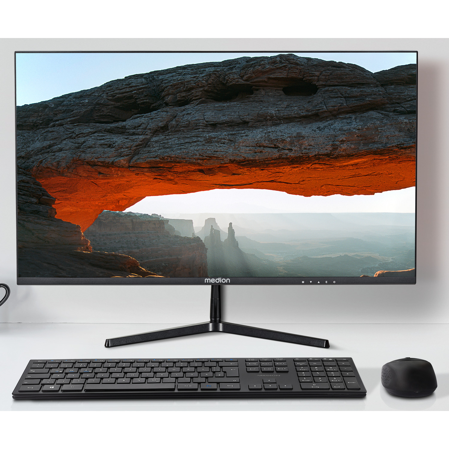 Un écran d'ordinateur avec un clavier noir, une souris et une image de paysage.
