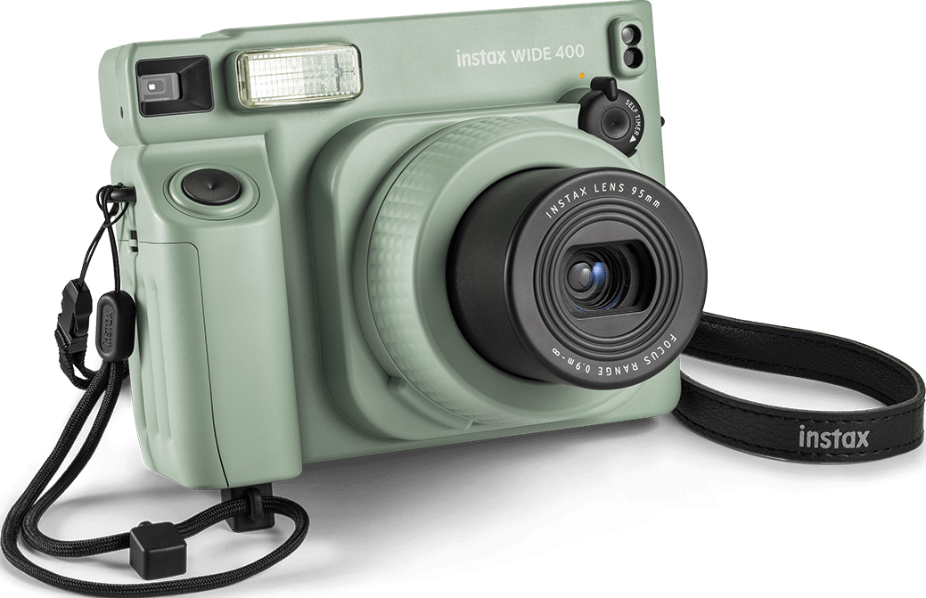 Grüne Instax Wide 400 Kamera mit schwarzem Objektiv. Die Kamera hat einen Gurt. Schwarzer Hintergrund.