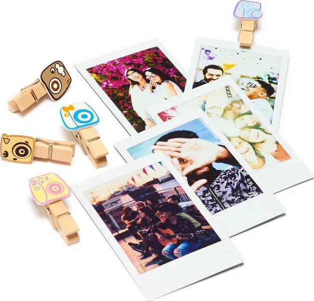 Foto Polaroid con persone e clip decorative a forma di fotocamera. Le immagini mostrano gruppi, primi piani e scene all'aperto.