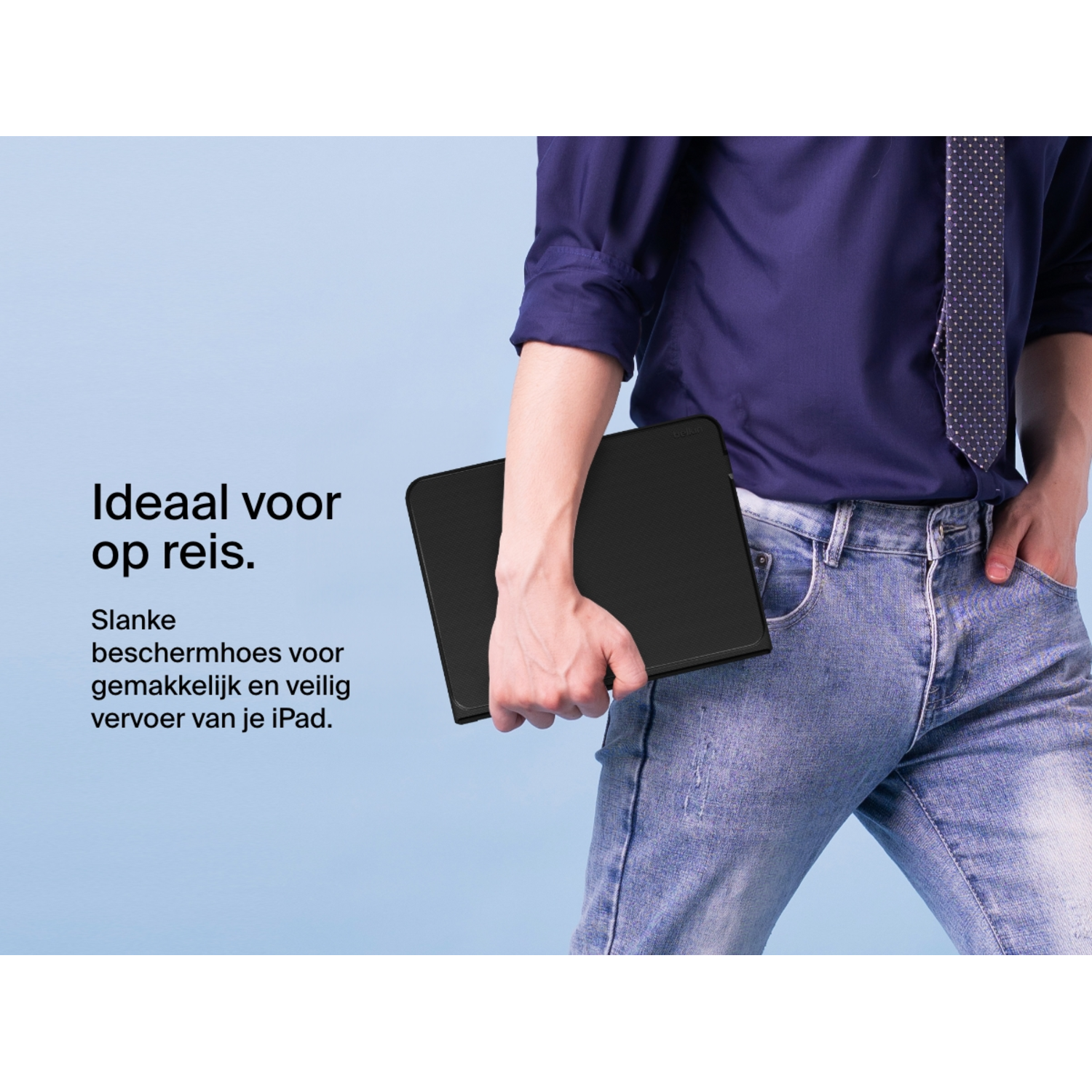 A man holds a black iPad in a black case, wearing jeans and a blue shirt.