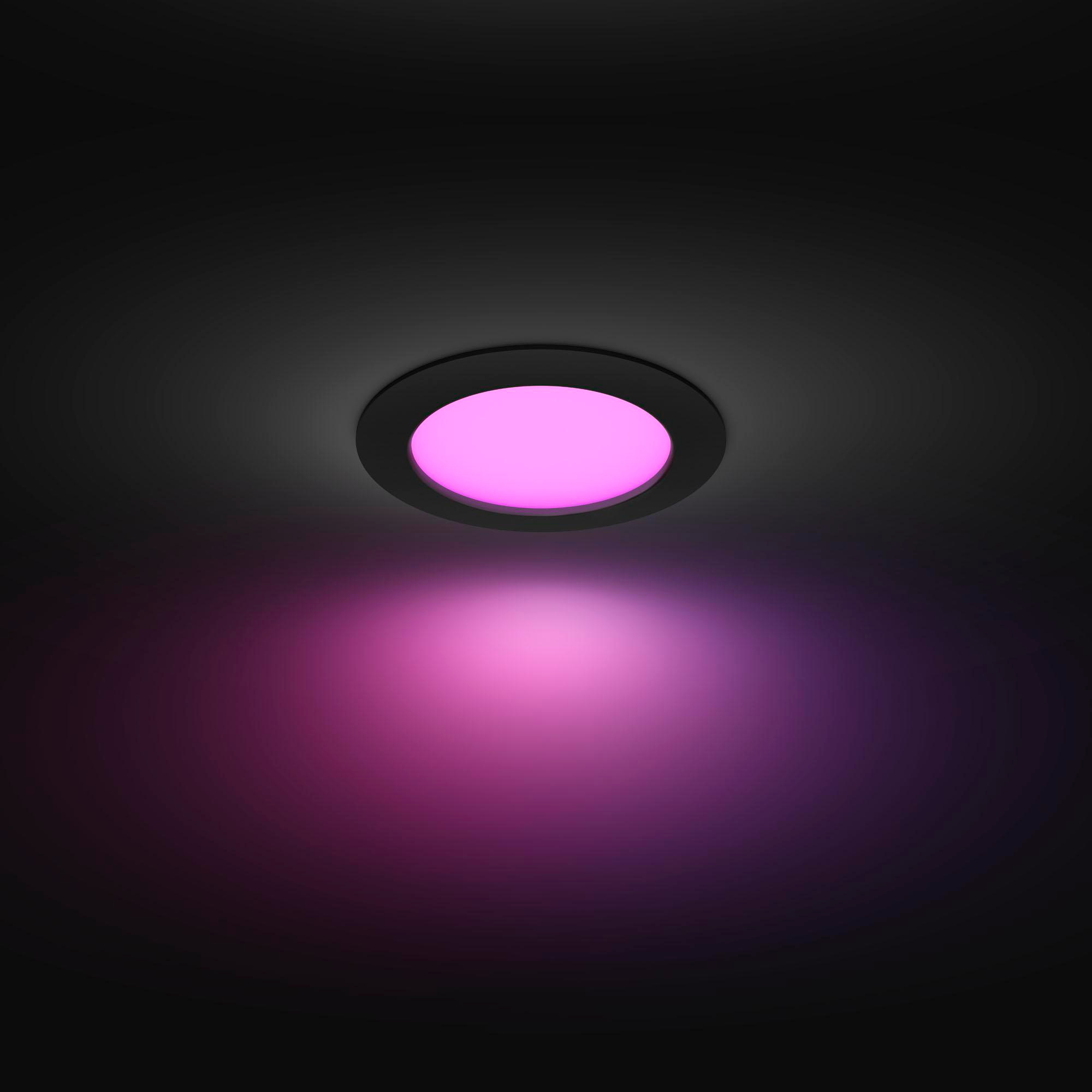 Deckenleuchte, die ein rosa Leuchten aussendet, mit dunklem Hintergrund.