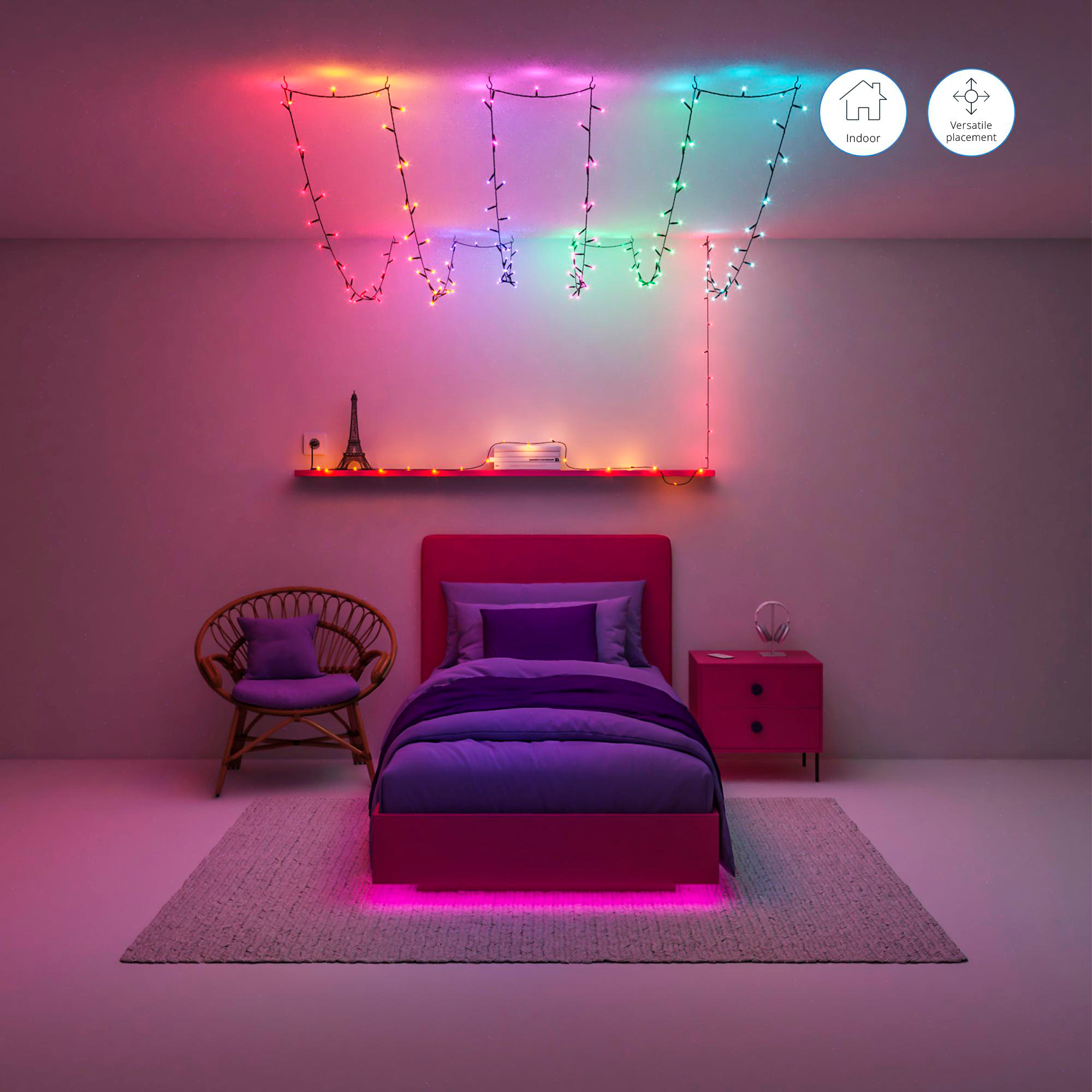 Ein Schlafzimmer mit pinkfarbenem Bett, Lichtern und einem Regal mit einem Miniatur-Eiffelturm.