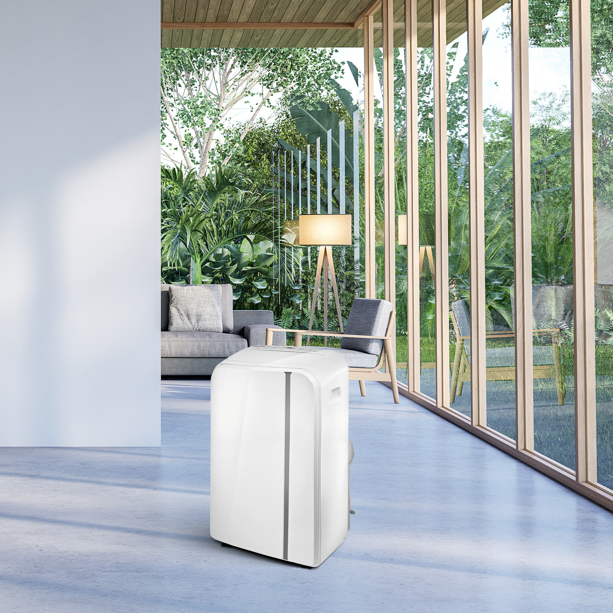 Biały przenośny klimatyzator w nowoczesnym pokoju z dużymi oknami i zielenią na zewnątrz.