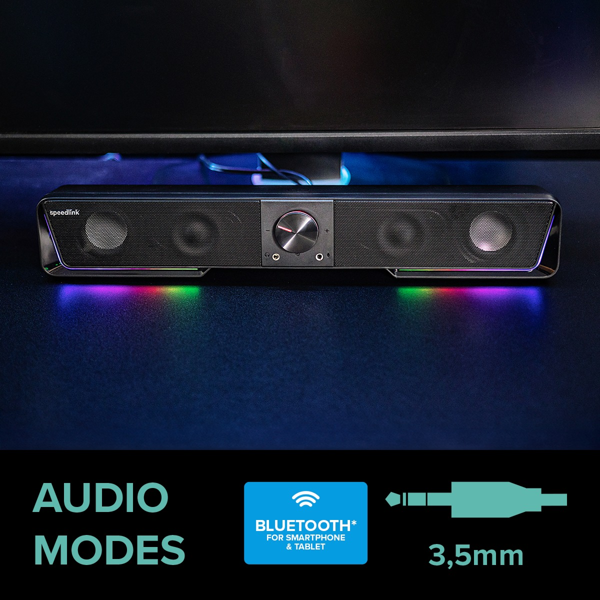 Eine schwarze Soundbar mit bunten Lichtern unten, die auf einer schwarzen Oberfläche steht.