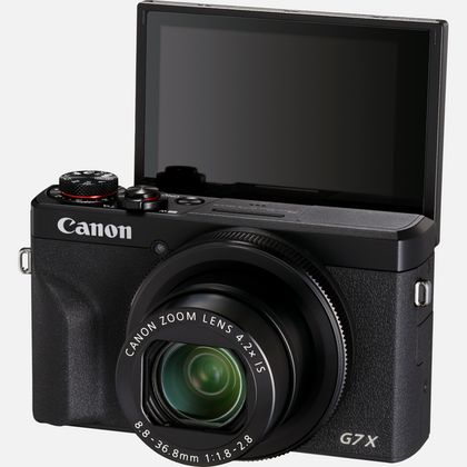 Schwarze Canon-Kamera mit hochgeklapptem Bildschirm. Canon Zoom-Objektiv sichtbar. Schwarze Kamera mit silbernem Objektiv.