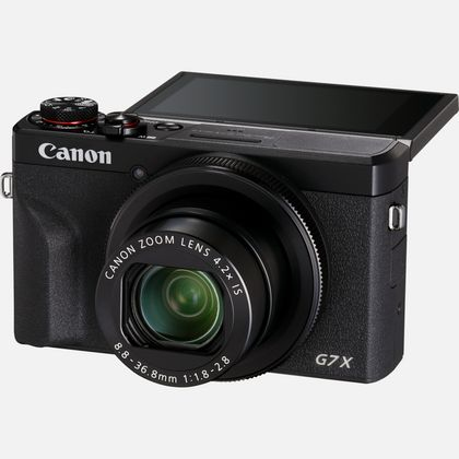 Schwarze Canon G7X Kamera, angewinkelt, Objektiv offen, Bildschirm offen.