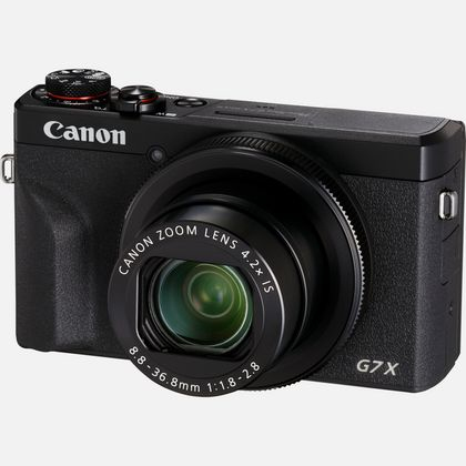 Schwarze Canon-Kamera mit seitlich gerichtetem Objektiv. Schwarz mit Canon Zoom-Objektiv. Die Kamera hat die Aufschrift G7X.