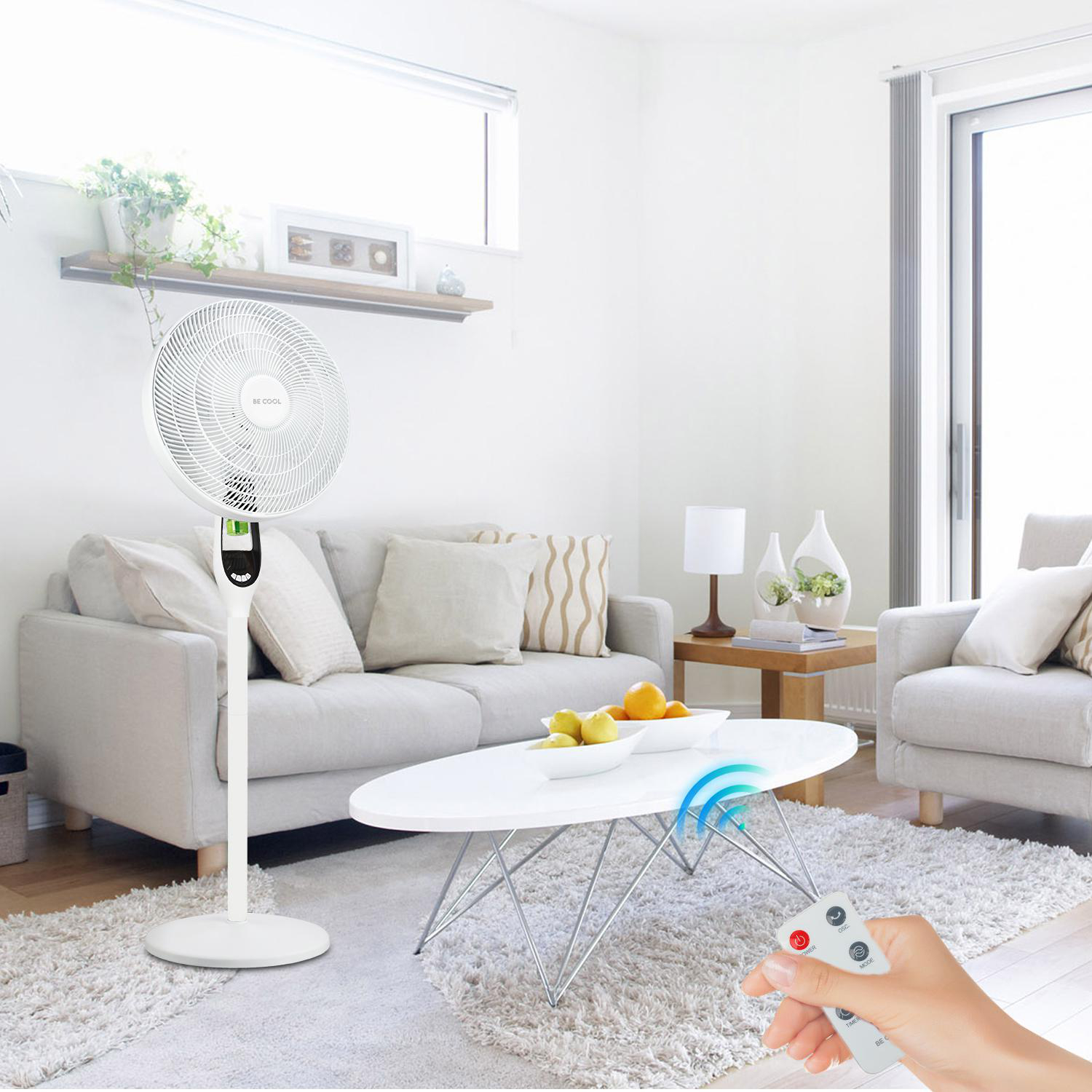 Ein weißer Ventilator steht in einem Wohnzimmer, mit einer Fernbedienung im Vordergrund.