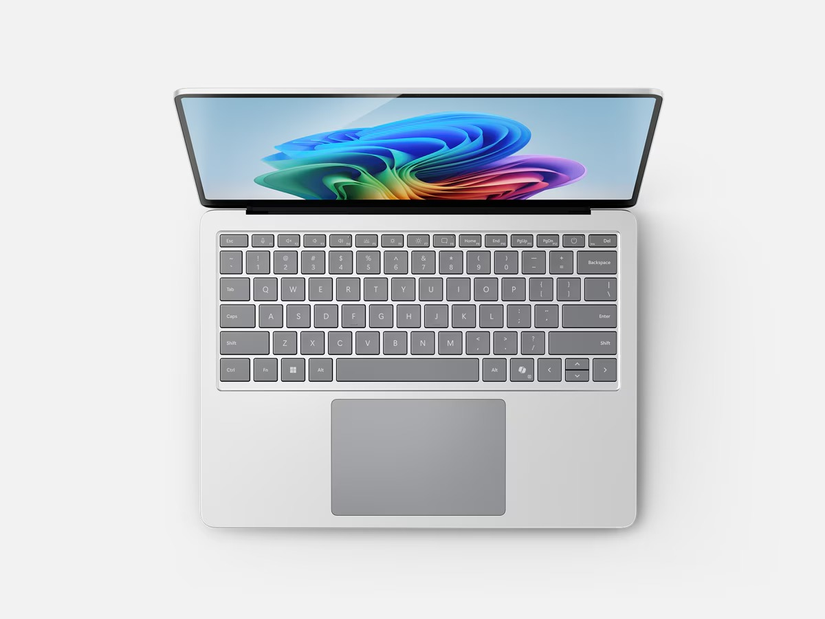 Zilveren laptop met het scherm open. Het toetsenbord en de touchpad zijn zichtbaar.