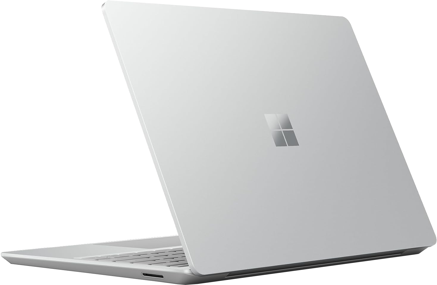 Ezüst laptop Microsoft logóval a hátulján, nyitva. Billentyűzet látható. Fekete háttér.
