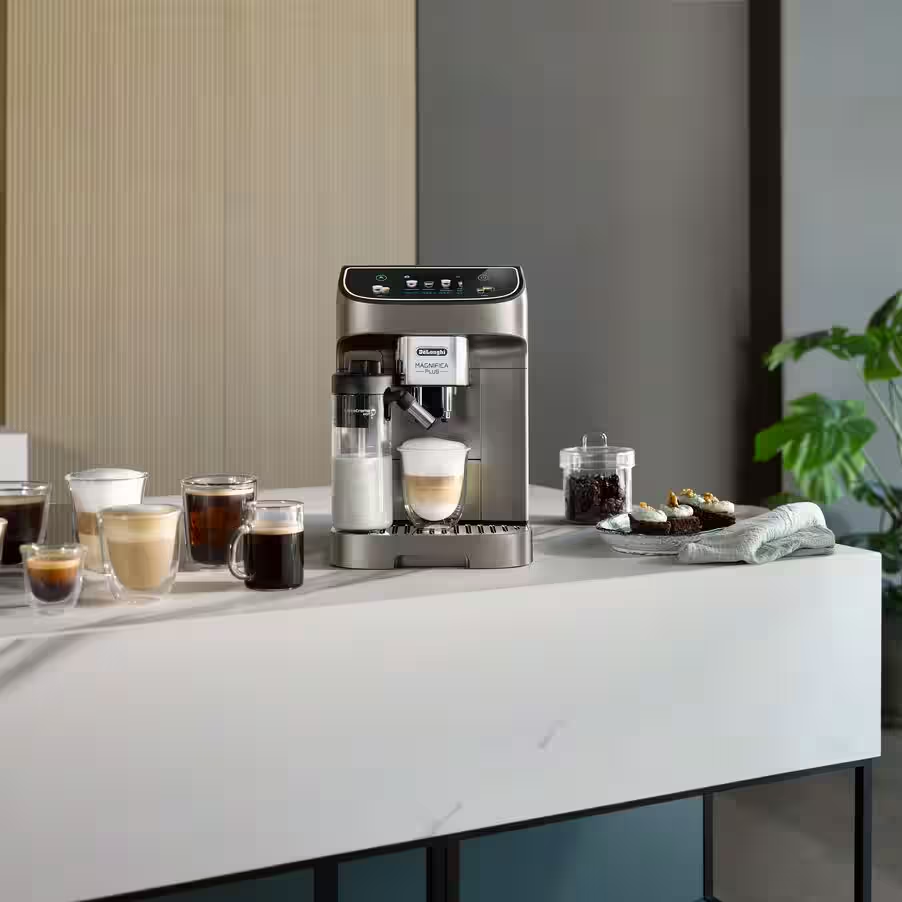 Macchina per espresso che fa il caffè. Diverse tazze piene di caffè sul tavolo. Interni marroni e bianchi.