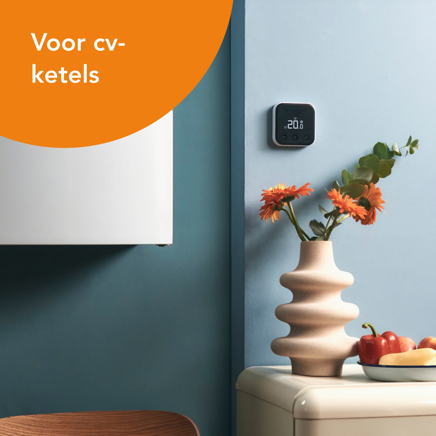 Een interieur met een thermostaat en bloemen op een tafel, en tekst.