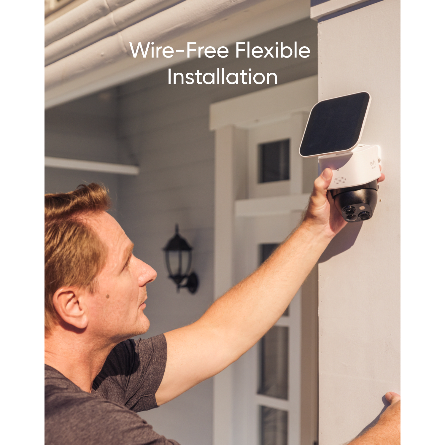 Man installing white security camera with solar panel on white wall. Text: Wire-Free Flexible Installation.