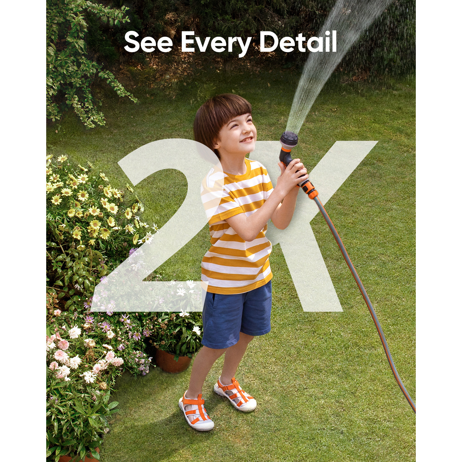 A boy sprays water with a hose. He is wearing a striped shirt.