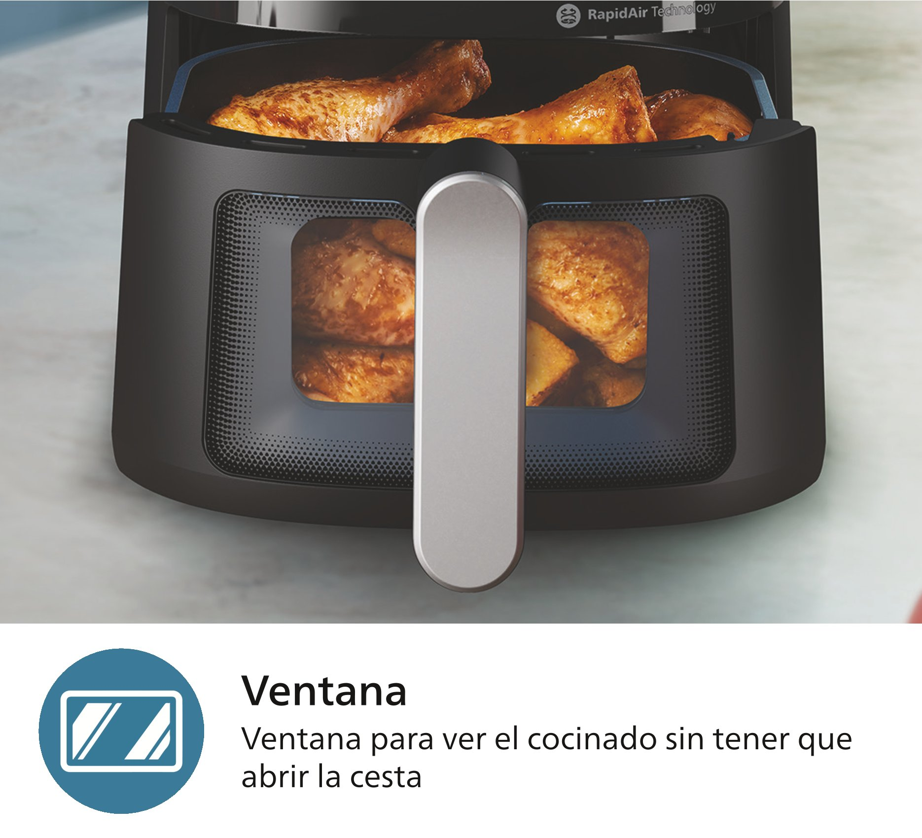 Freidora de aire negra con pollo cocinado visible a través de ventana de vidrio.
