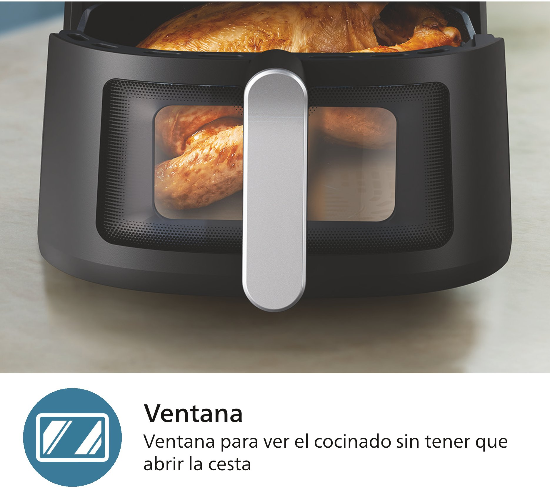 Freidora negra con asa plateada, mostrando pollo cocinado a través de una ventana transparente.