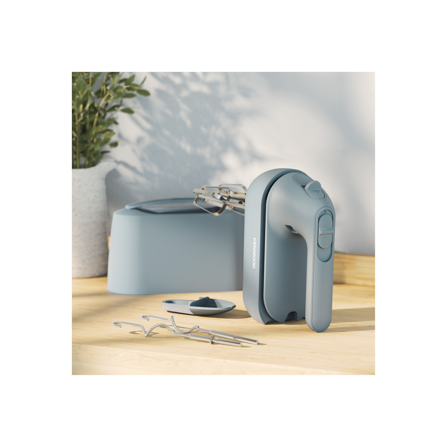 Handmixer en accessoires op een houten tafel. Lichtblauwe kleur.