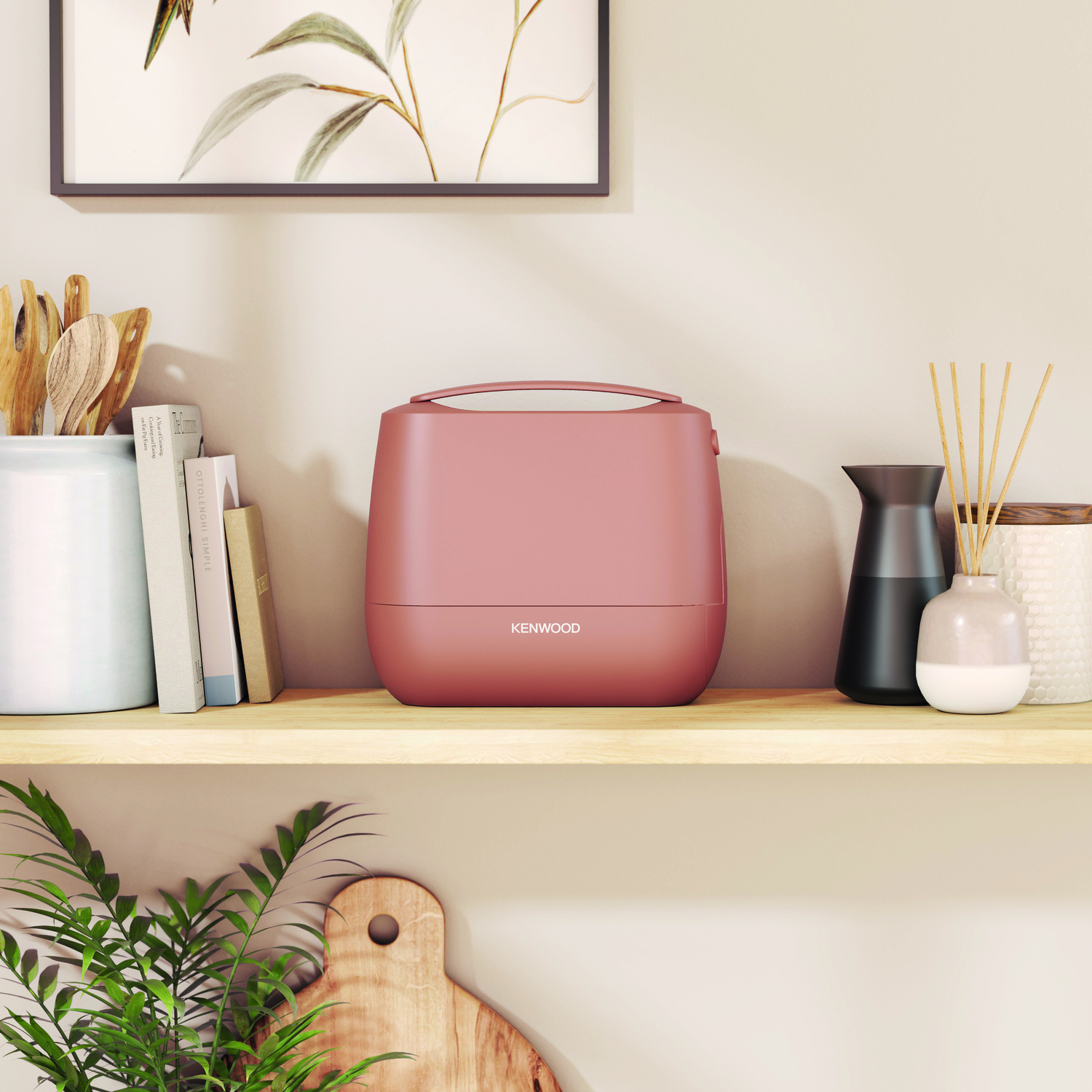 A pink hand mixer's case is shown on a shelf with decor. The case is closed.