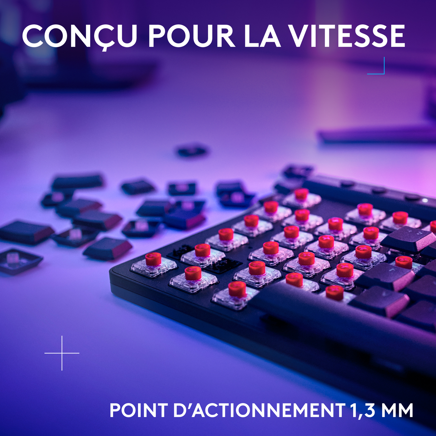 Gros plan sur un clavier avec des interrupteurs mécaniques rouges, éclairé par une lumière violette.
