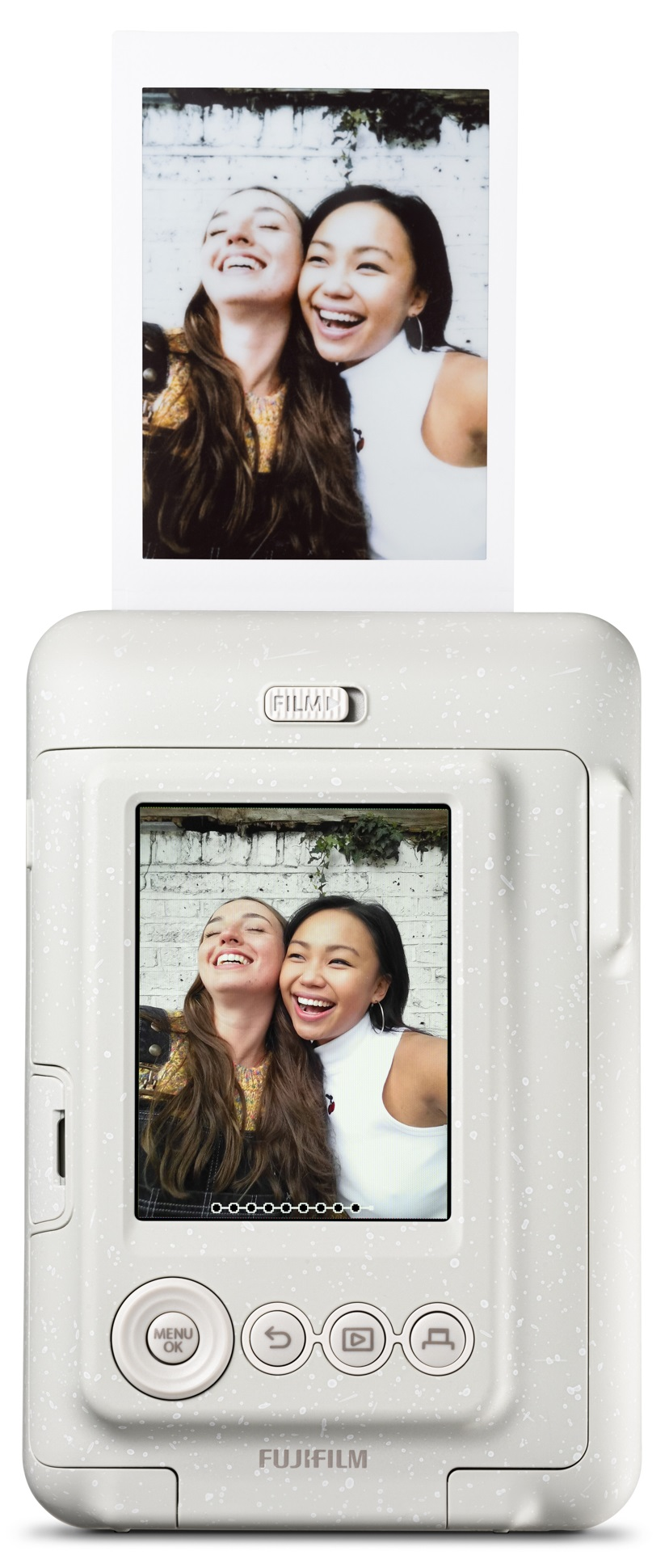 Biały aparat natychmiastowy z wydrukowanym zdjęciem dwóch uśmiechniętych kobiet, częściowo wysuniętym zdjęciem.