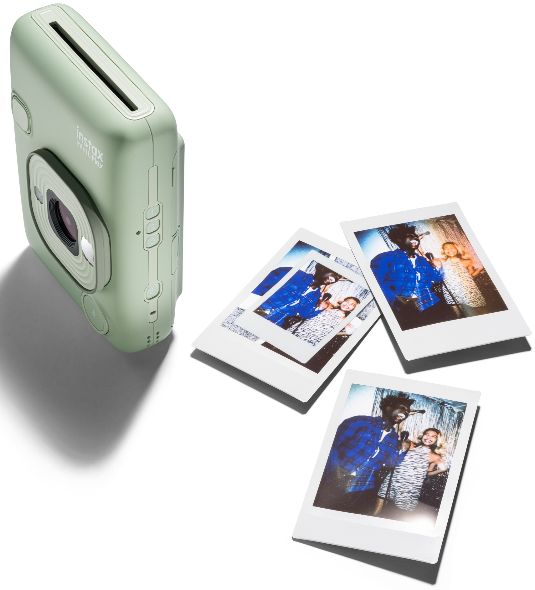 Miętowy aparat Instax Mini LiPlay z trzema zdjęciami na białej powierzchni.