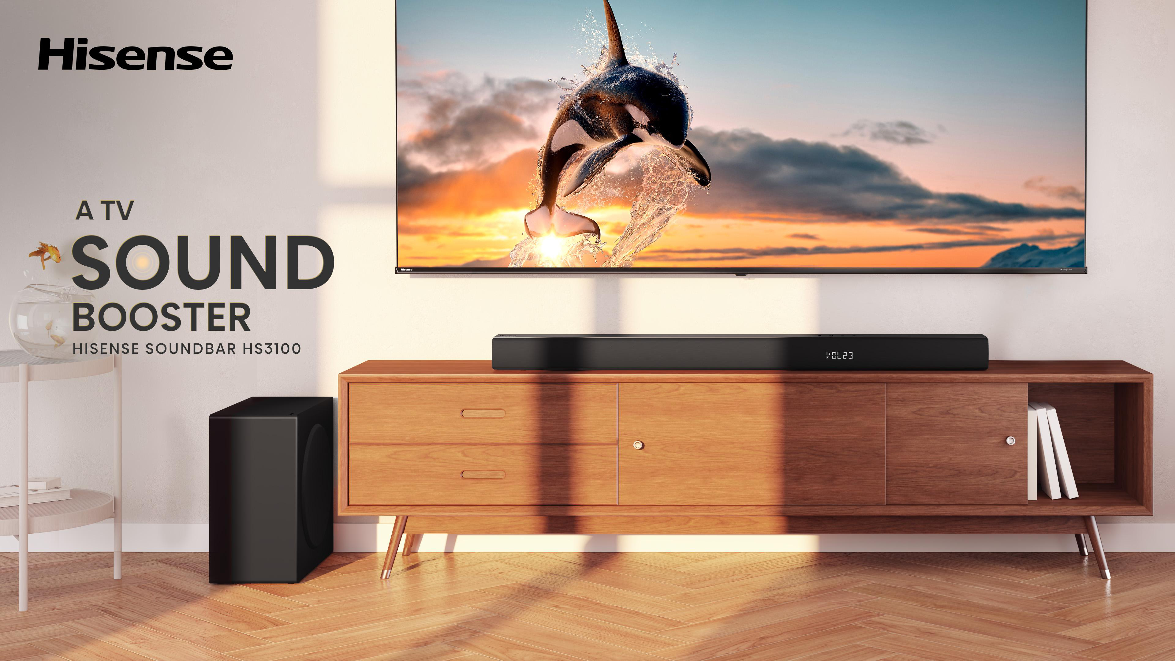 Hisense-Fernseher mit Soundbar und Subwoofer. Der Fernseher zeigt einen Orca, der im Sonnenuntergang springt. Holzschrank.