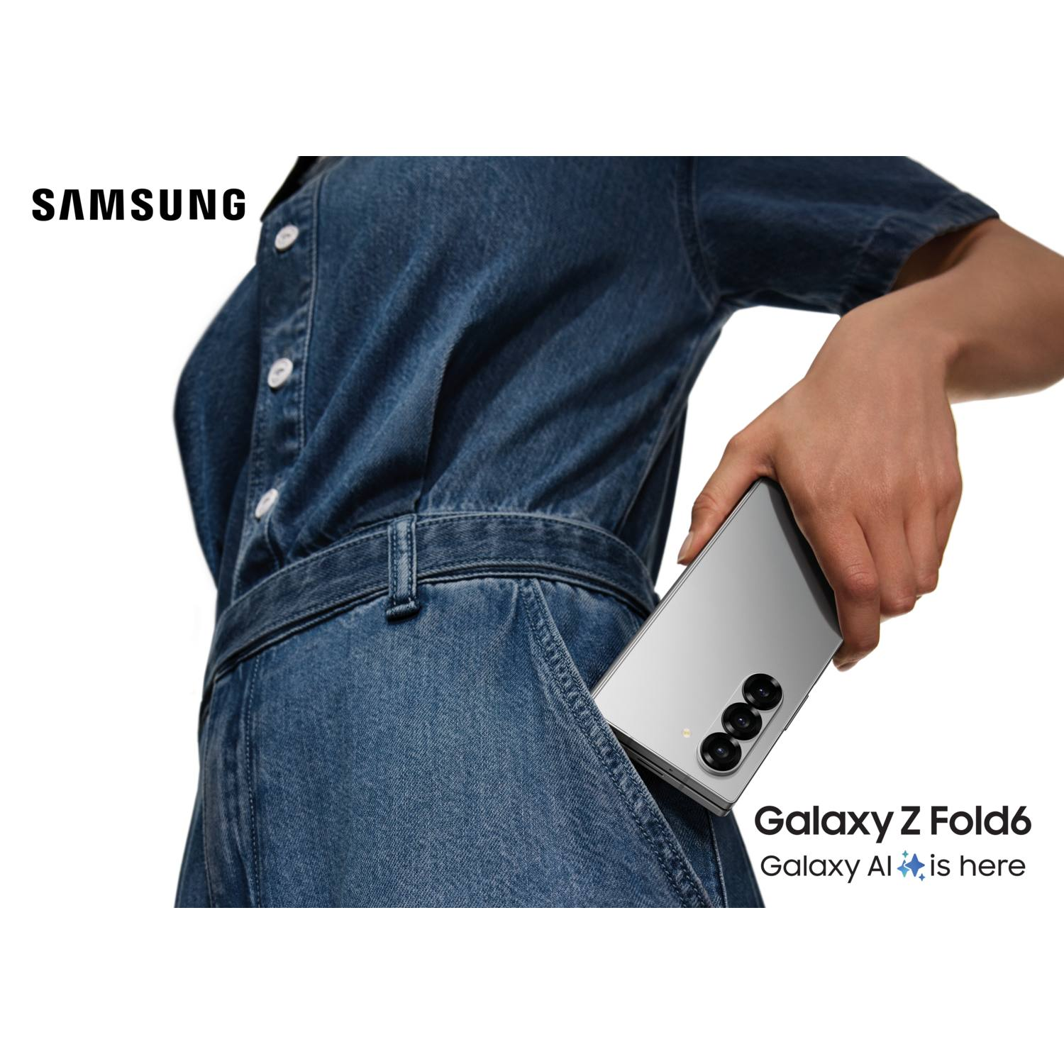 Femme tenant un téléphone pliable argenté, dans une combinaison en jean.