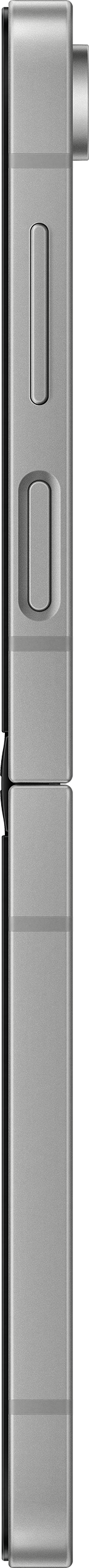 Une vue latérale d'un smartphone argenté. Il a des boutons et un port de chargement.