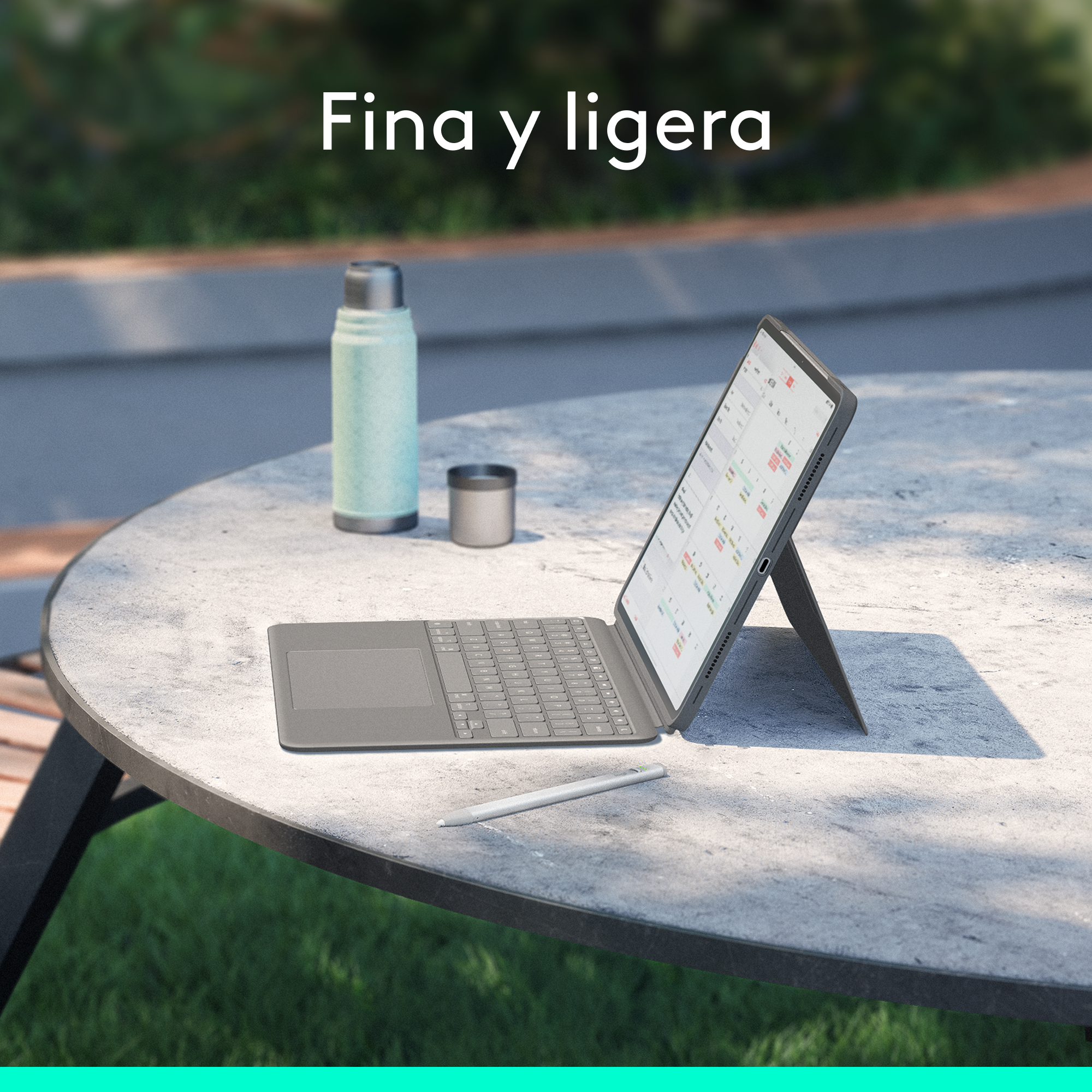 Una tableta con teclado y lápiz en una mesa, con un paisaje al fondo.