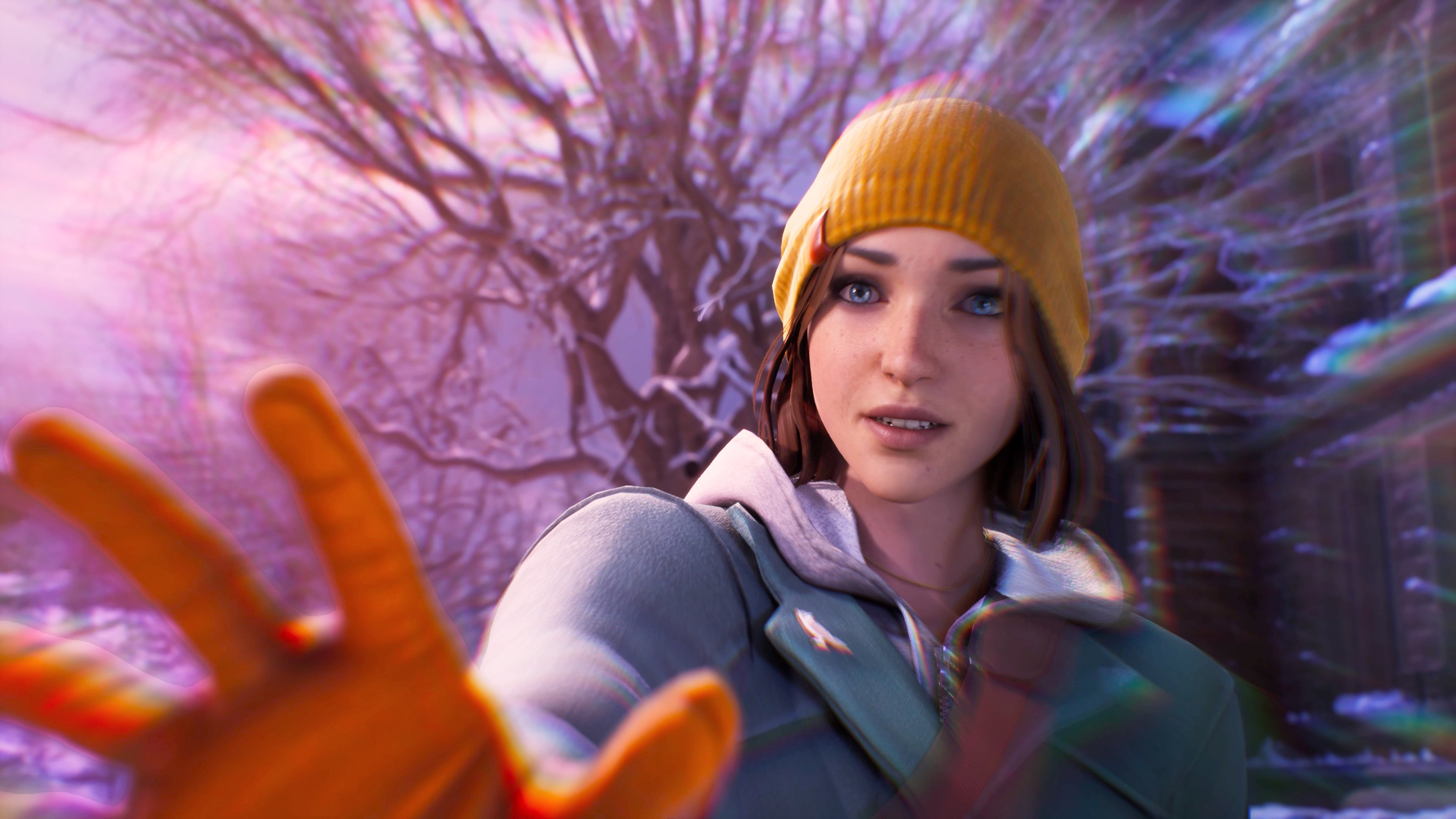 Donna che si protende verso la fotocamera, con cappello giallo e giacca verde.