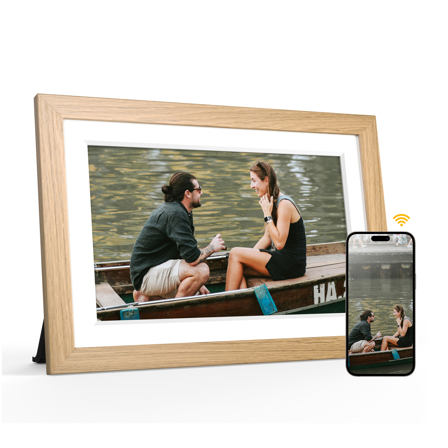 Una cornice con una foto di due persone su una barca, con uno smartphone vicino.