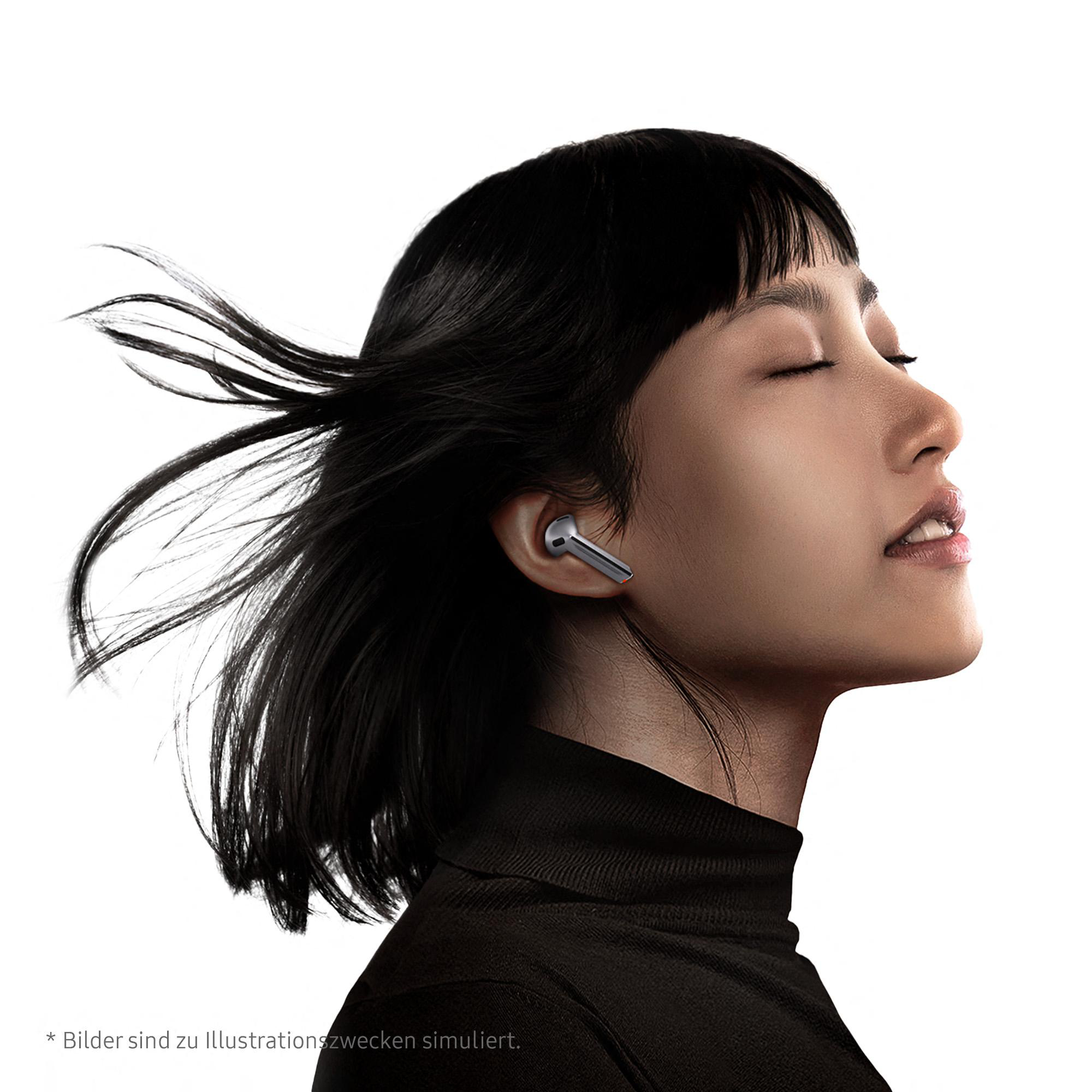 Eine Frau mit Ohrhörern in den Ohren, die nach oben schaut. Sie hat schwarzes Haar.