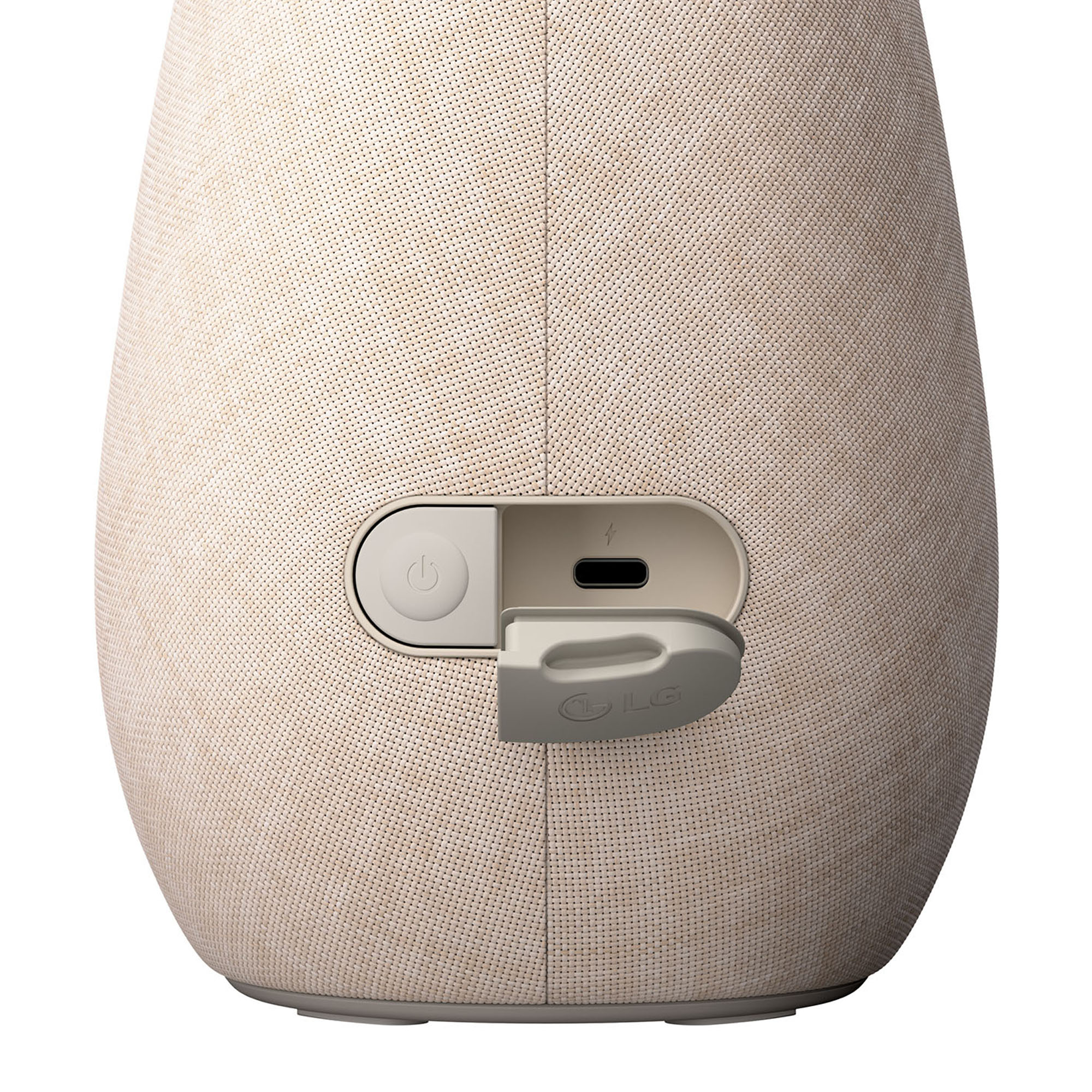 Un altavoz LG beige con los puertos de alimentación y carga visibles. Una pequeña puerta está abierta.
