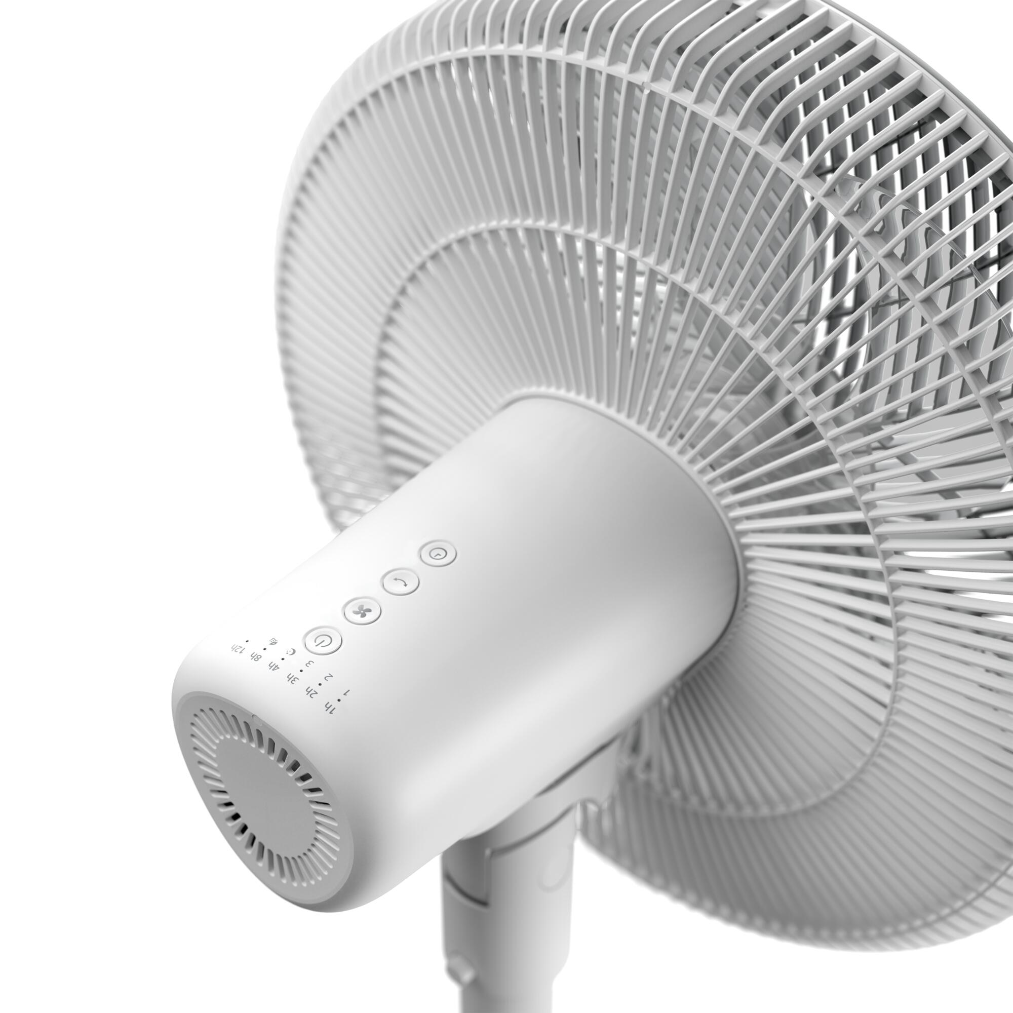 Primer plano de un ventilador de pedestal blanco con un fondo blanco, con las aspas del ventilador visibles.