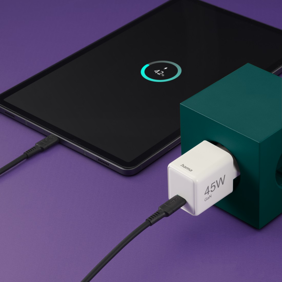 Ein Tablet wird mit einem weißen 45W GaN-Ladegerät geladen, das mit einem grünen Block verbunden ist.
