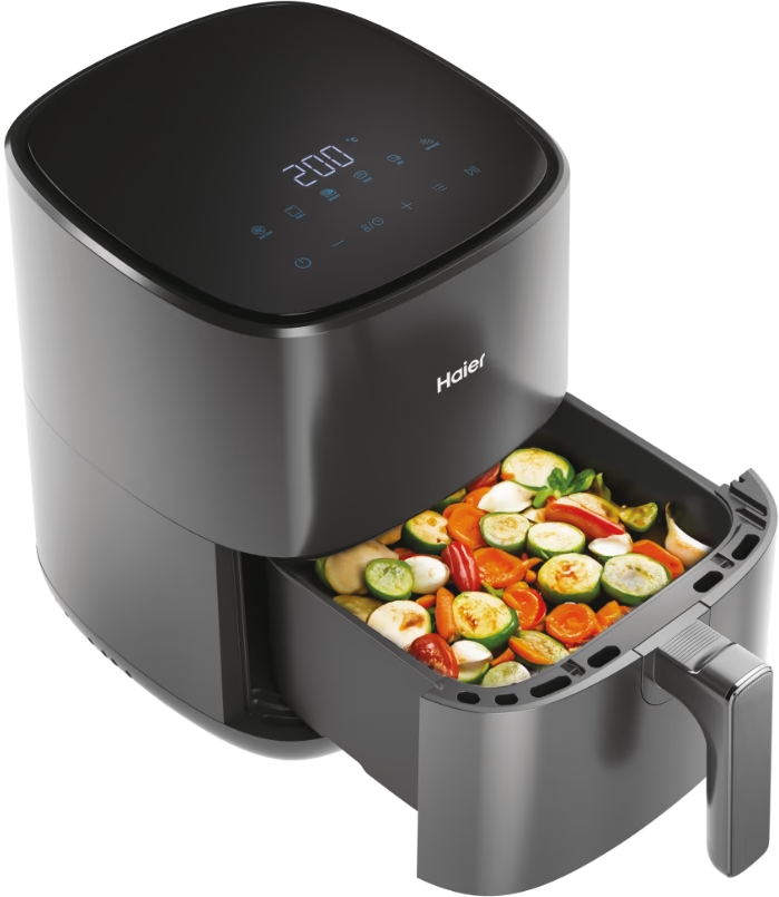 Une friteuse à air avec un tiroir rempli de légumes.