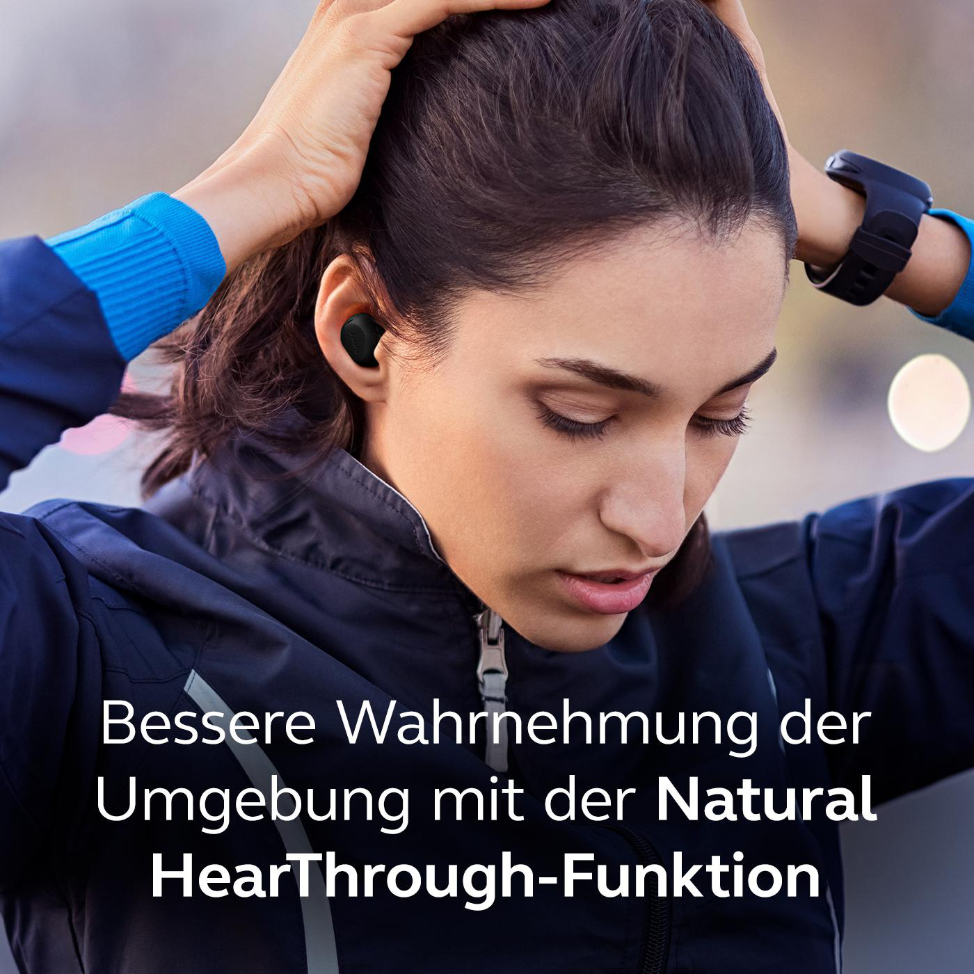 Eine Frau mit Ohrhörern, die sich am Kopf berührt, mit Text über HearThrough.