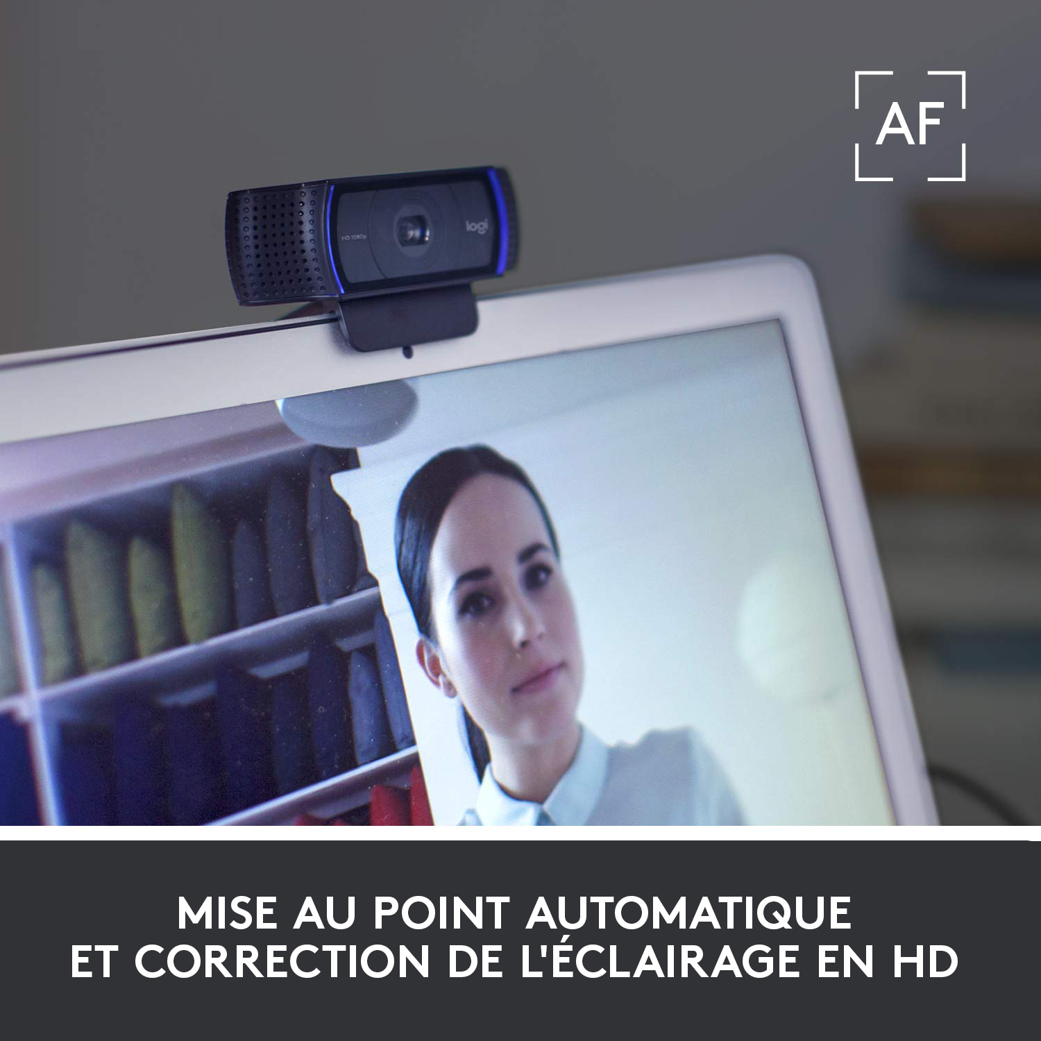 Une webcam montée sur un ordinateur portable, montrant une femme à l'écran. Texte: mise au point et éclairage HD automatiques.