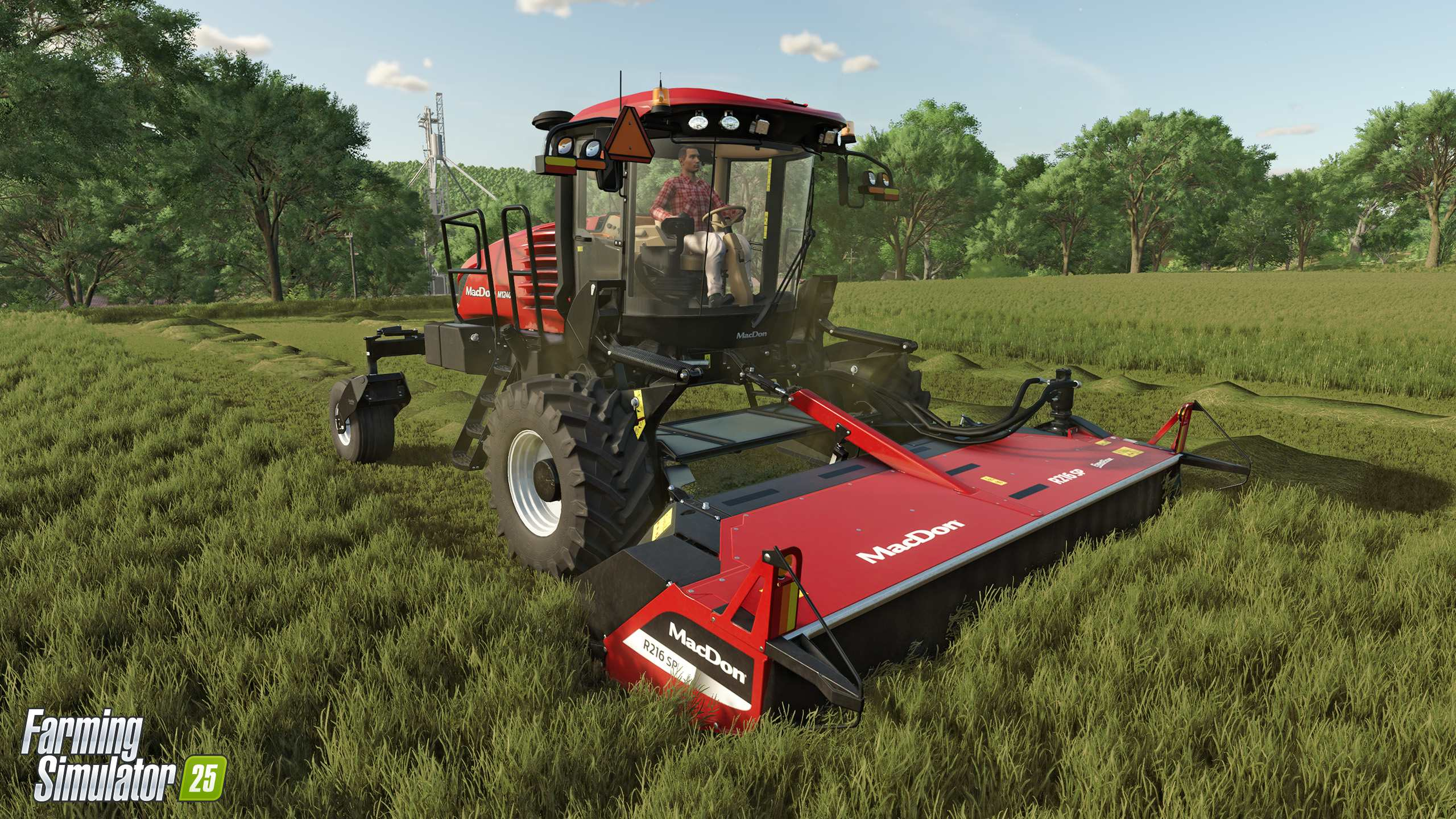 Un tracteur rouge et noir coupant l'herbe dans un champ.