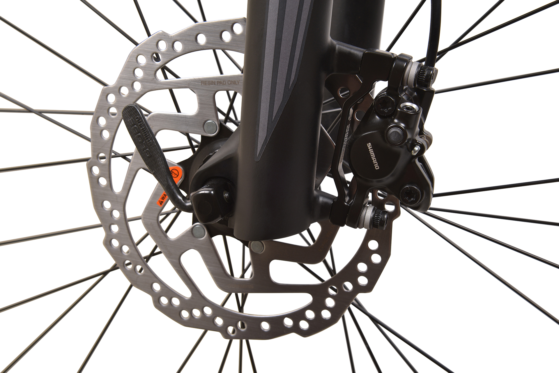 Zbliżenie systemu hamulców tarczowych roweru z widocznym rotorem, zaciskiem i szprychami.