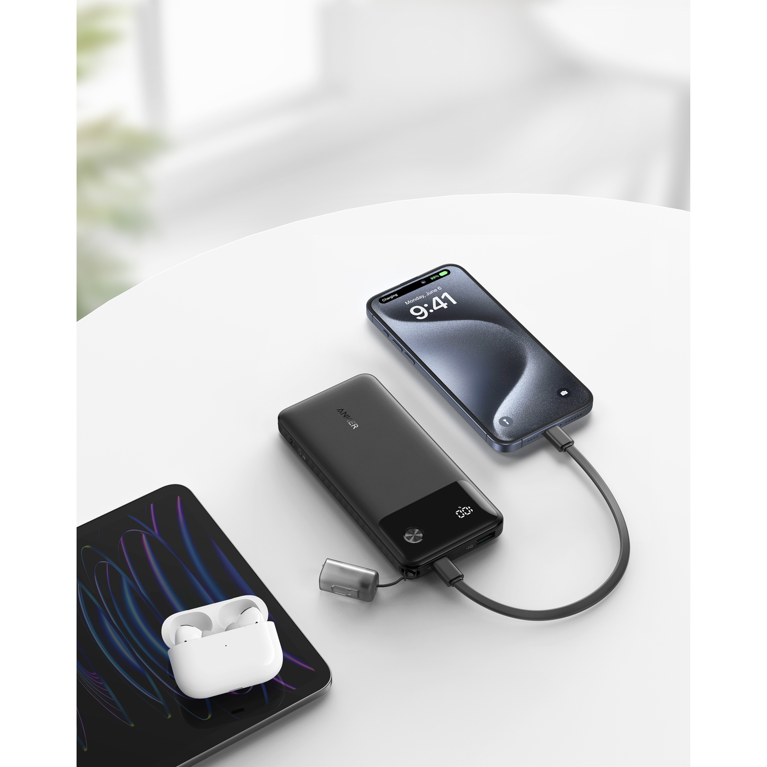 Een zwarte powerbank die een telefoon en andere apparaten oplaadt.