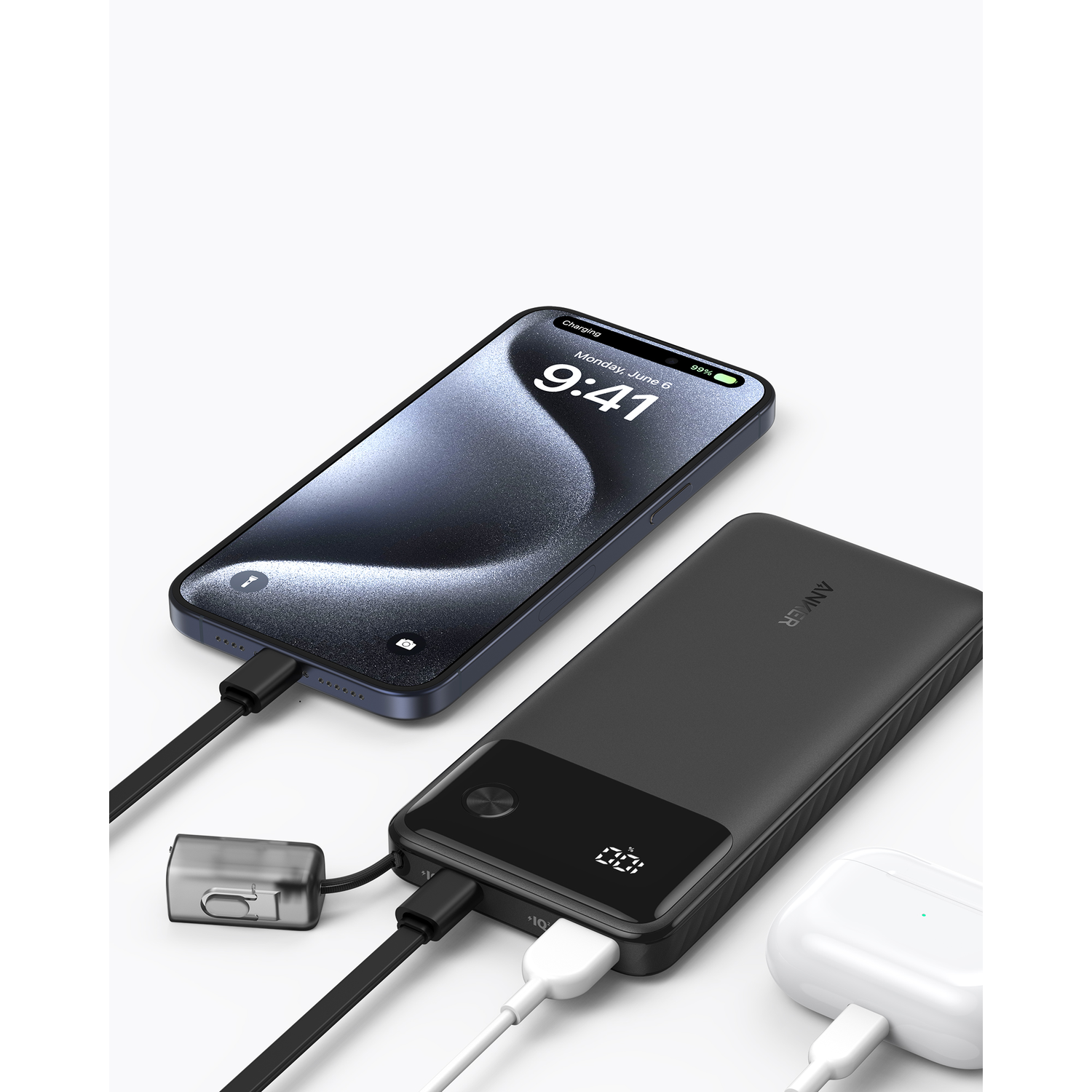 Een zwarte Anker powerbank met een telefoon die oplaadt en oordopjes.