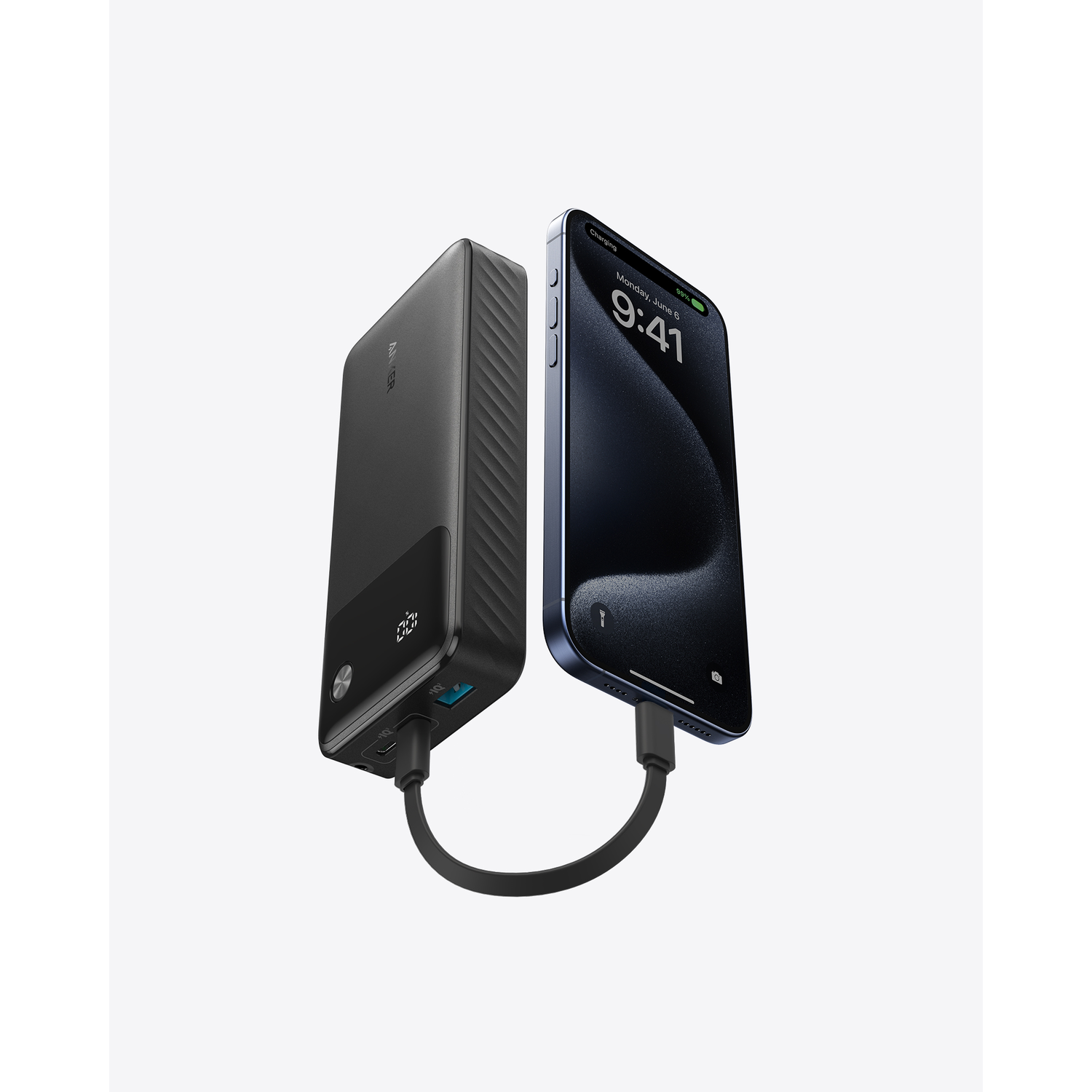 Zwarte powerbank verbonden met een telefoon met een oplaadkabel. De telefoon toont zijn scherm.