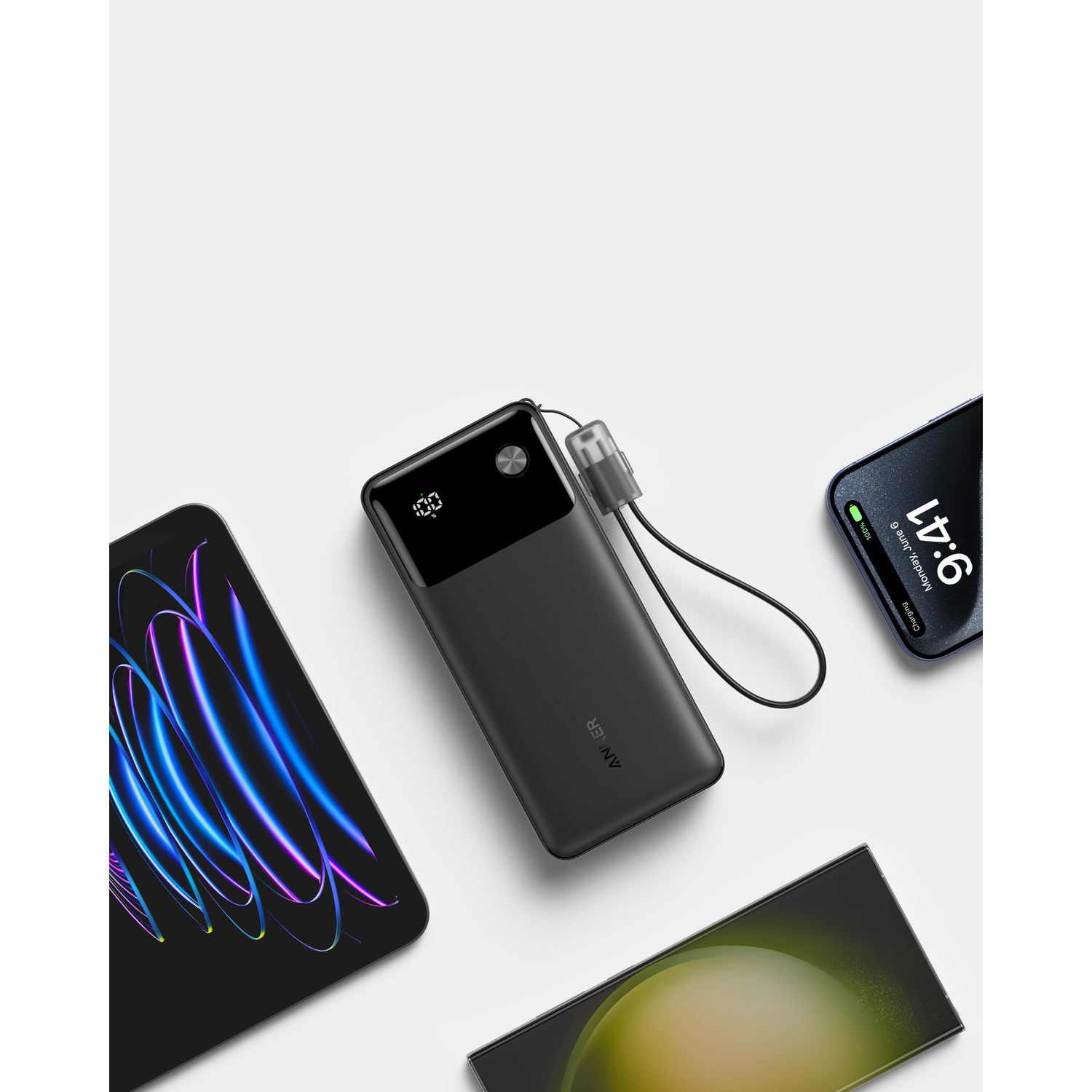 Een zwarte powerbank met een display dat 100% weergeeft en een zwarte telefoon op een wit oppervlak.