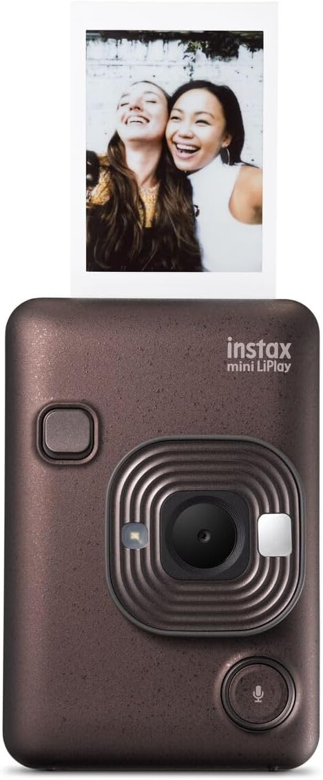 Cámara Instax marrón con foto expulsada. Una foto sonriente está encima.