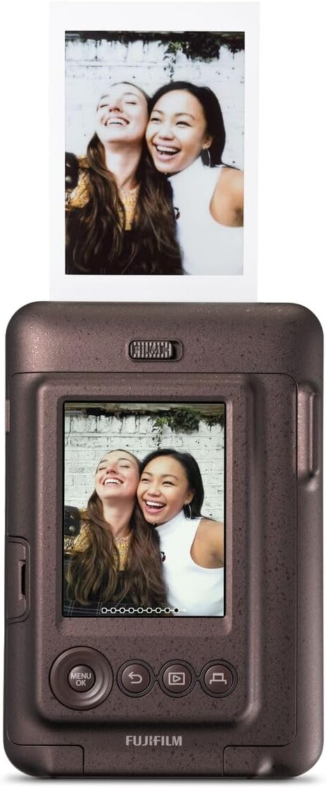 Cámara instantánea con foto de dos mujeres sonriendo, con foto y cámara visibles.