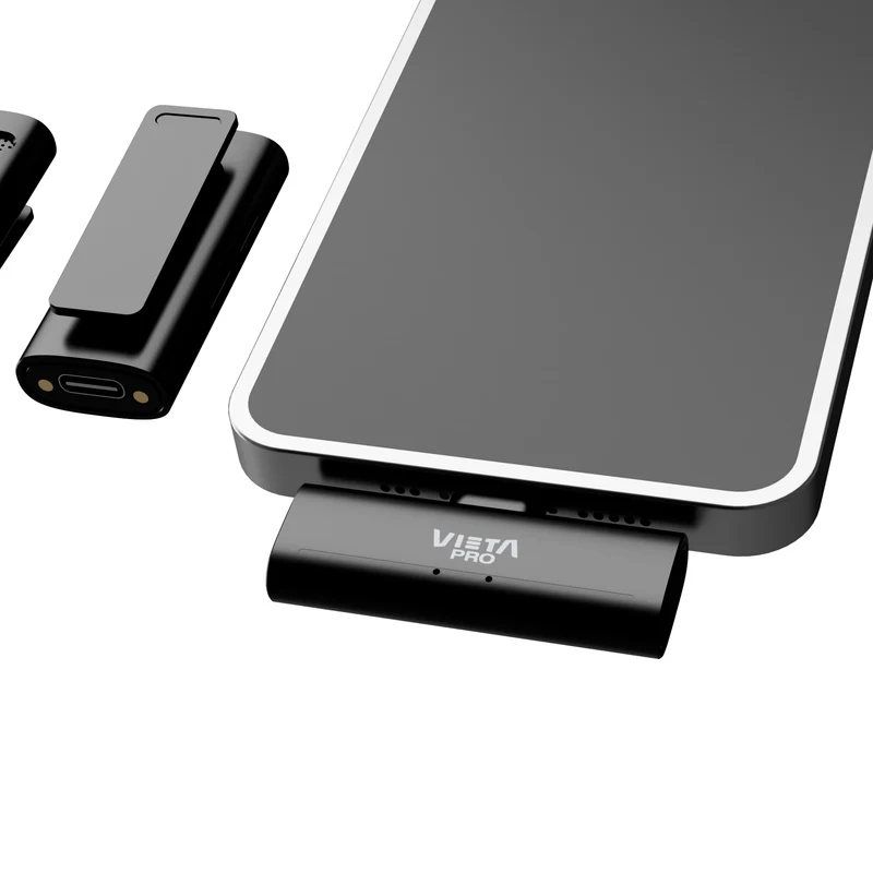 Dispositivo VISTA PRO negro conectado a un teléfono. Otro dispositivo con clip visible.