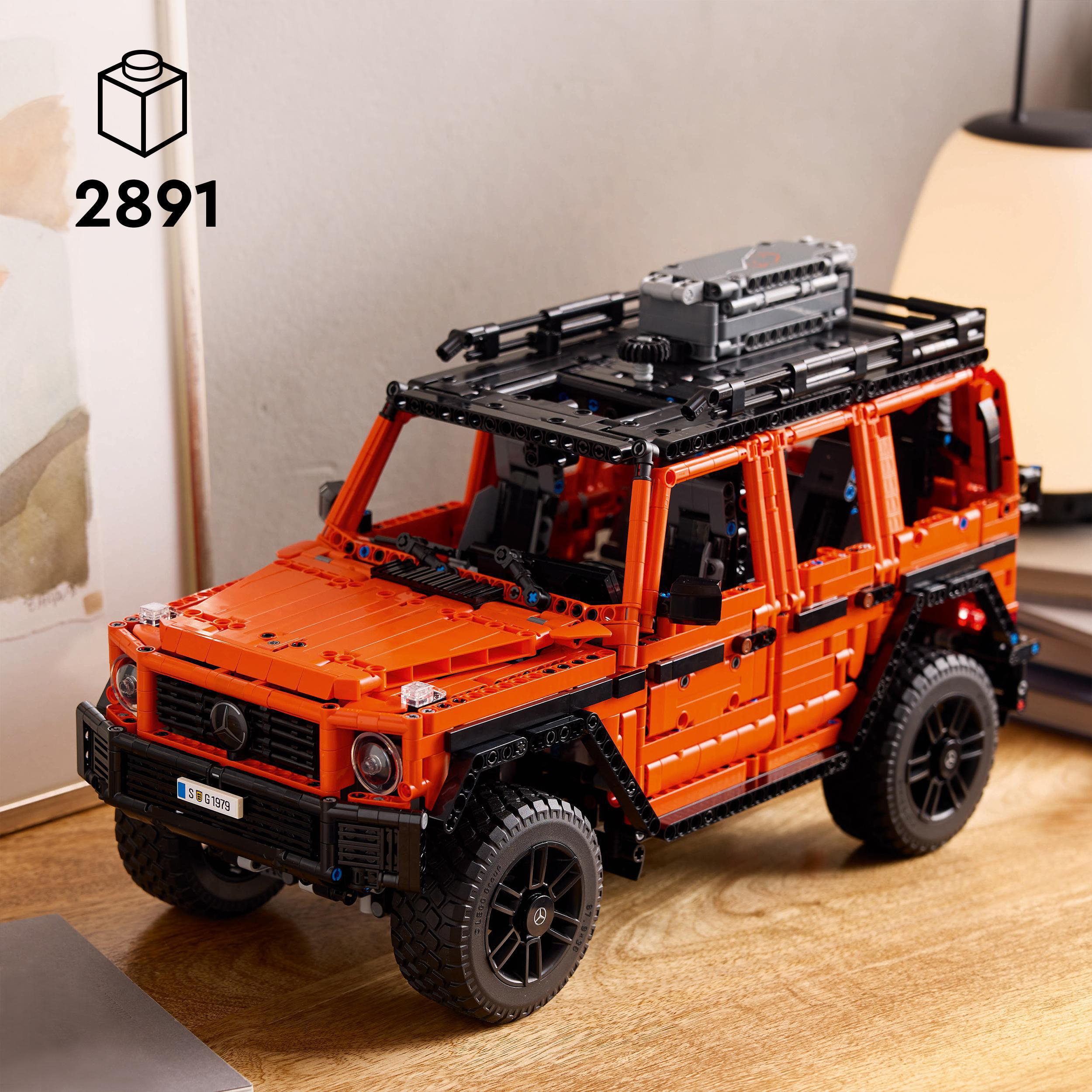 Oranges Lego-Automodell mit schwarzen Akzenten und Dachgepäckträger. Holztisch.